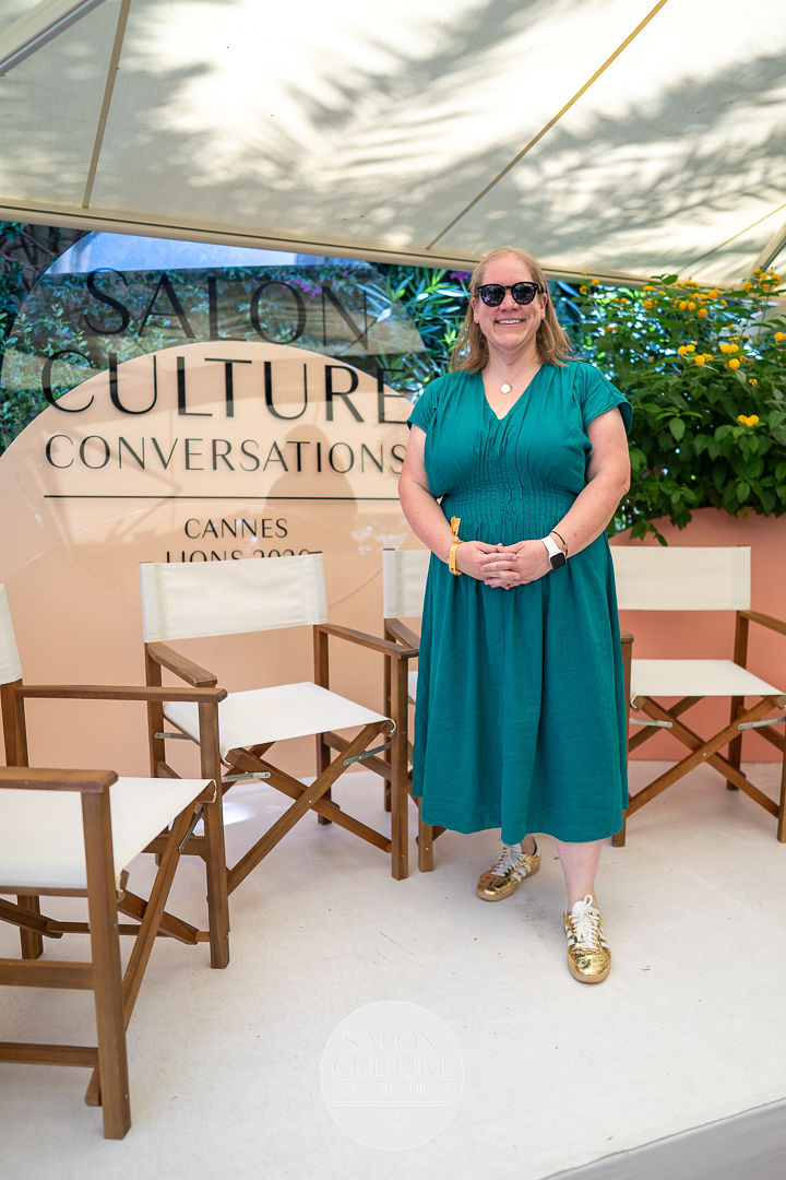 Carlee Wolfe standing beside the Salon Culture Conversations stage in Cannes.