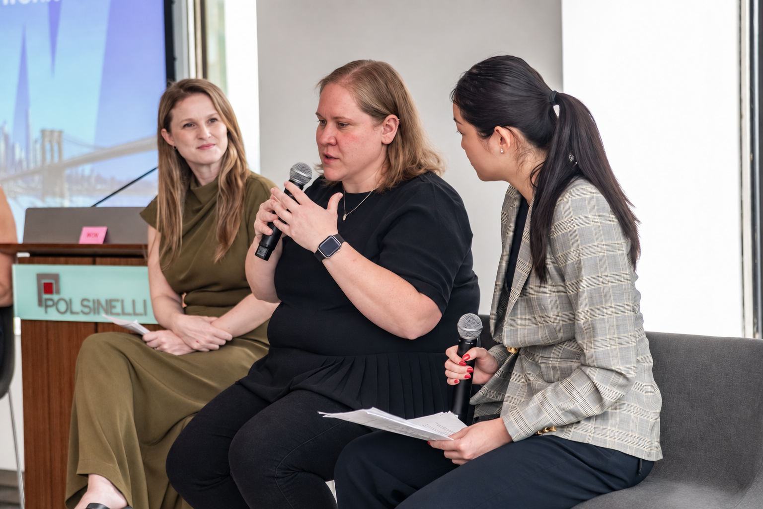 Carlee Wolfe speaking into a microphone during a WIN at Climate Week panel in New York.
